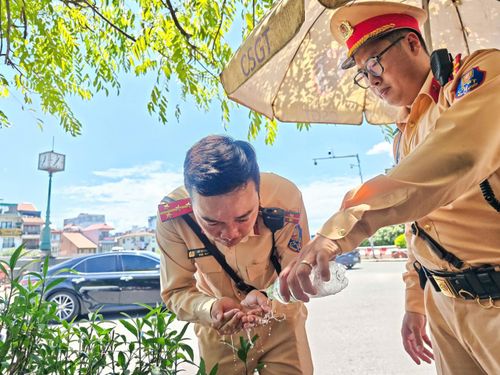 Cán bộ, chiến sĩ CSGT giải nhiệt bằng nước tại chốt làm việc. Ảnh: Phạm Công