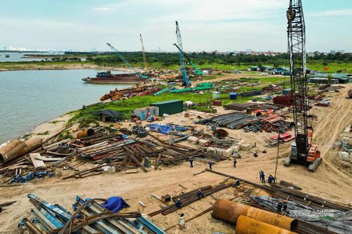 Khu vực bãi thi công ven sông tập trung nhiều máy móc, vật liệu và thiết bị chuyên dụng.