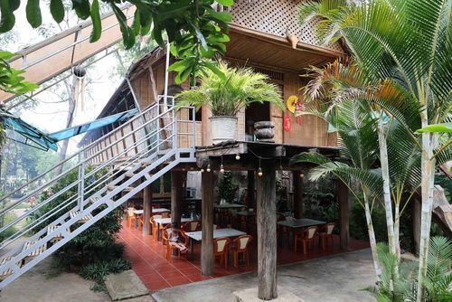 Ngôi nhà dài truyền thống của người M'Nông quanh hồ Lắk có view sân vườn bên dưới nhà. Ảnh: Kha Phạm - TTXVN