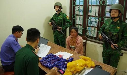 Lò Thị Hương cùng tang vật tại cơ quan điều tra. (Ảnh: ANH DŨNG)