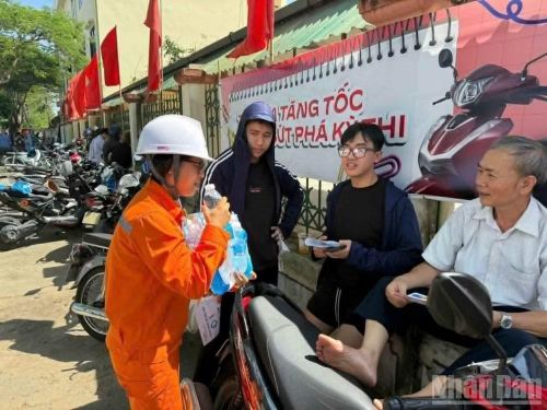 Phát nước uống cho người dân chờ con thi tuyển sinh lớp 10.