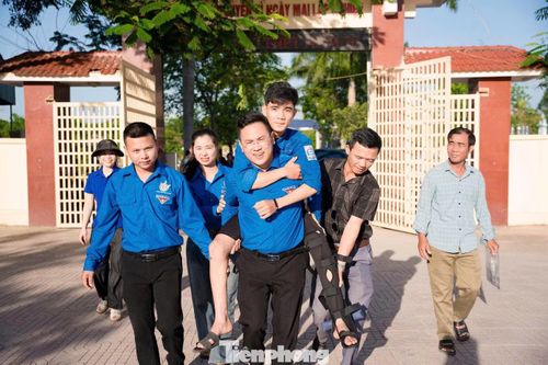 Hình ảnh đoàn viên thanh niên hỗ trợ thí sinh Trần Văn Tuấn Tú bị gãy chân đến phòng thi tại xã Bích Hào.
