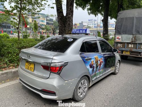 Chiếc xe có gắn mào hãng taxi Sao Thủ đô, BKS: 30F - 726.97 với thông tin quảng cáo về trang web cá độ cờ bạc trực tuyến, di chuyển trên đường Láng.