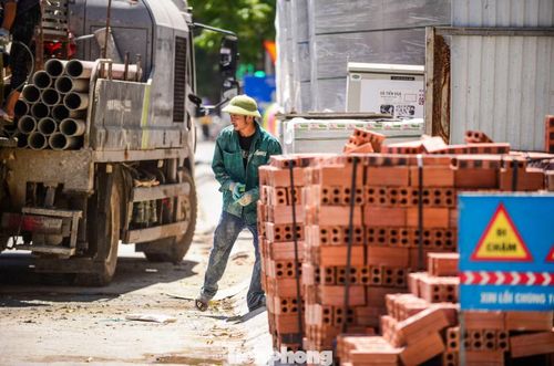 Dưới nắng gắt, người lao động vẫn miệt mài mưu sinh.