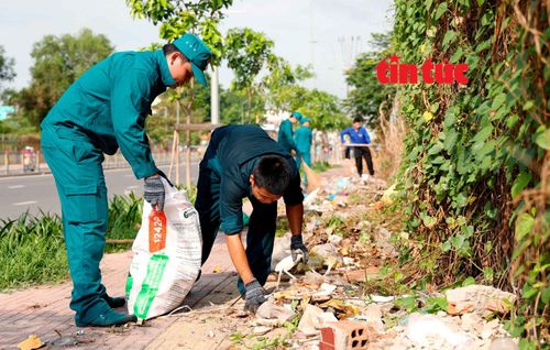 Lực lượng dân quân tự vệ đồng hành dọn dẹp rác thải, trả lại môi trường xanh, sạch đẹp tại vỉa hè ở địa bàn dân cư.