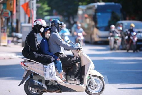 Người tham gia giao thông trên các tuyến phố trung tâm Hà Nội phải trang bị kín mít quần áo chống nắng, kính mát và khẩu trang để chống chọi với nền nhiệt tăng cao ngay từ sớm. Ảnh: Hoàng Hiếu - TTXVN