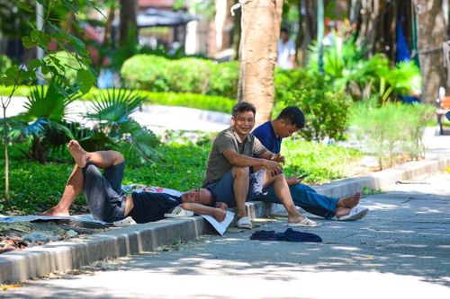 Dưới cái nắng như thiêu đốt, những giọt mồ hôi chảy dài trên khuôn mặt sạm nắng của người lao động. Sau nhiều giờ làm việc liên tục, một số người tranh thủ tìm bóng mát dưới gầm cầu, gốc cây hay hiên nhà ven đường để nghỉ trưa, lấy lại sức trước khi tiếp tục công việc.