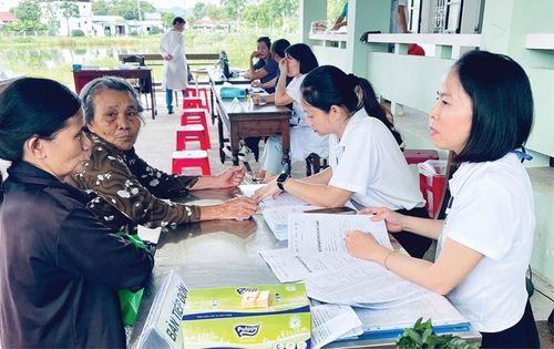 Cán bộ y tế phường Hương Trà tiếp đón người dân đến làm thủ tục kiểm tra sức khỏe. Ảnh: Vinh Nguyễn