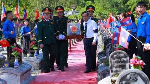 Đồng chí Nguyễn Trọng Nghĩa (bên trái) cùng các đại biểu di chuyển hài cốt liệt sĩ đến nơi an táng.