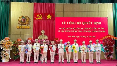 Đồng chí Giám đốc Công an tỉnh Ninh Bình trao quyết định, tặng hoa cho đại diện các đồng chí được thăng cấp bậc hàm, nâng lương.