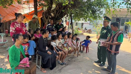 Già làng Điểu Pêm cùng cán bộ Biên phòng tuyên truyền, phổ biến pháp luật cho người dân. Ảnh: Thanh Phong