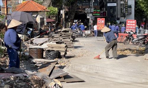 Công nhân căng mình trong nắng nóng thi công sửa chữa mặt đường dẫn lên cầu Long Biên.
