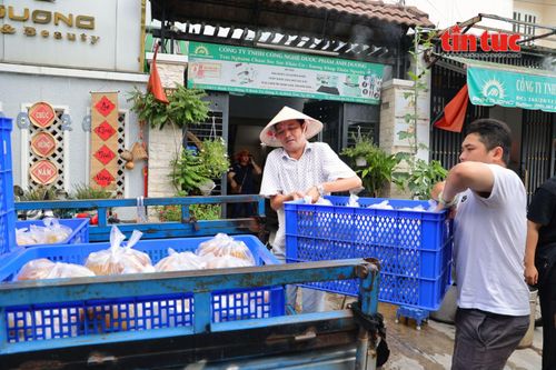 Anh Trần Việt Cường (bên trái) cùng các thành viên nhóm thiện nguyện vận chuyển những suất cơm lên xe để mang đến bệnh viện trao cho bệnh nhân chạy thận.