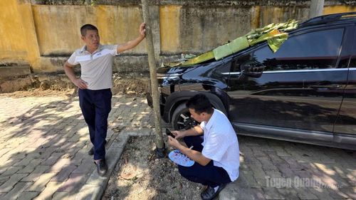 2 phụ huynh chờ con tại điểm thi Trường THPT Ỷ La, phường Minh Xuân.