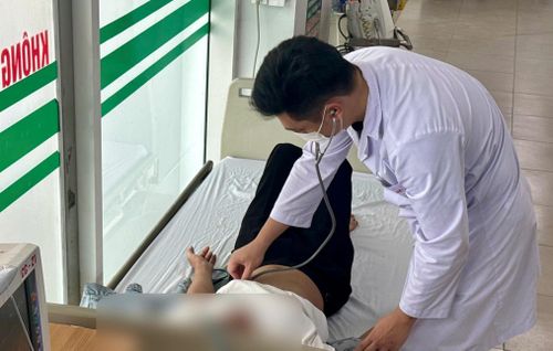 Nam shipper được bác sĩ thăm khám sau tai nạn khi giao hàng giữa trời nắng nóng. (Ảnh: Đặng Thanh)