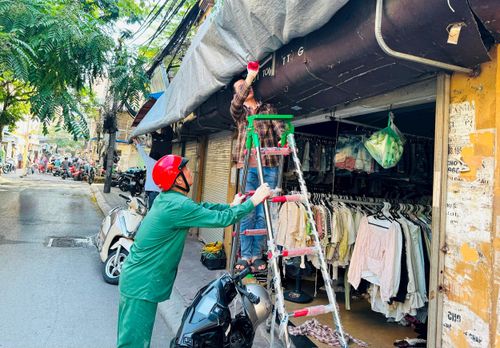 Lực lượng chức năng phường Kim Liên xử lý mái che, mái vẩy trên tuyến phố Tôn Thất Tùng. Ảnh: PV