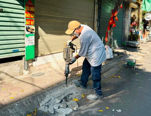 Lực lượng chức năng phường Kim Liên xử lý bục bệ sai quy định trên tuyến phố Tôn Thất Tùng. Ảnh: PV