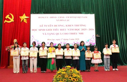 Phó Bí thư Thường trực Đảng ủy xã Hòa Lạc Nguyễn Thị Bích Ngọc trao thưởng cho các em học sinh giỏi. Ảnh: PV