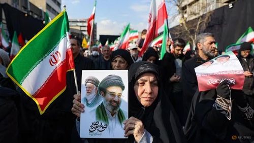 Một người phụ nữ cầm tấm áp phích in hình tân Lãnh tụ Tối cao Iran Mojtaba Khamenei bên cạnh cố Lãnh tụ Tối cao Iran Ayatollah Ali Khamenei tại Tehran, Iran. Ảnh: Reuters. 