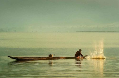 Người M'Nông đánh bắt cá trong lòng hồ Lắk bằng thuyền độc mộc. Ảnh: Kha Phạm - TTXVN
