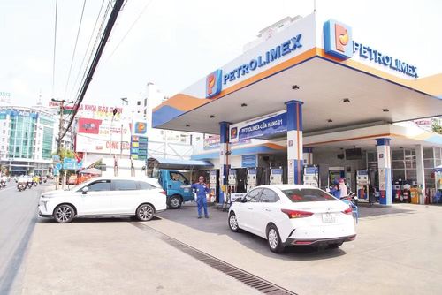 Nhân viên cửa hàng thuộc hệ thống Petrolimex tại tỉnh An Giang đổ xăng cho khách hàng. (Ảnh: QUỐC TRINH)