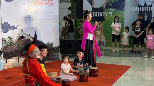 Các em thiếu niên, nhi đồng trải nghiệm nghệ thuật chèo với sự hướng dẫn của nghệ sĩ.
