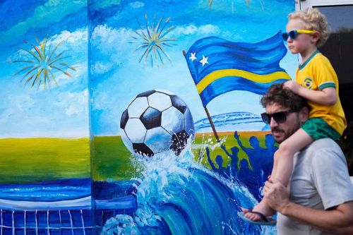 Du khách đi ngang qua bức tranh tường ăn mừng chiến tích Curaçao giành vé dự FIFA World Cup tại Willemstad ngày 14/5/2026.
