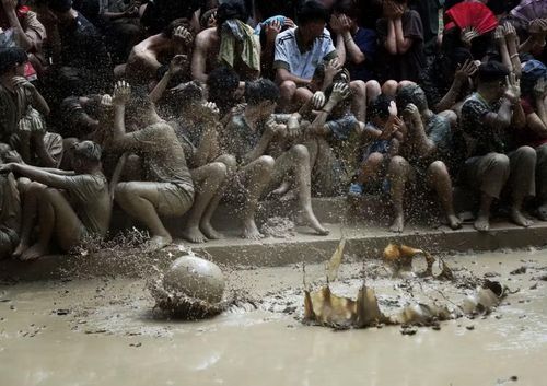 Người dân xem hội được “lộc bùn” bắn vào được coi là may mắn. (Ảnh: Danh Lam/TTXVN)