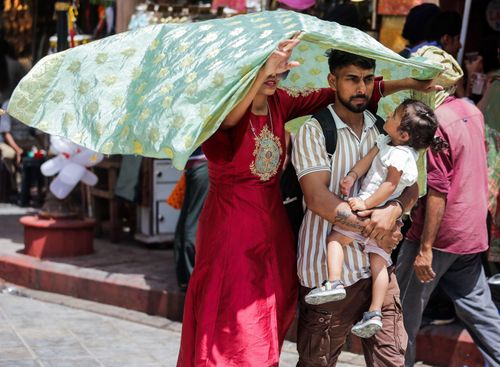 Người dân di chuyển dưới trời nắng gắt tại Amritsar, Ấn Độ. Ảnh: ANI/TTXVN