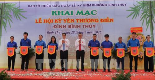 Lãnh đạo thành phố Cần Thơ trao cờ lưu niệm cho đại diện 17 khu vực trên địa bàn phường Bình Thủy tham dự lễ. Ảnh: Nguyễn Hằng - TTXVN