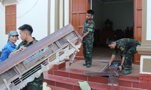 Chiến sĩ Trung đoàn 833 giúp người dân dọn dẹp đồ đạc để bàn giao đất ở.