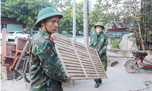 Khắc phục nắng nóng, các cán bộ, chiến sĩ nỗ lực giúp người dân vận chuyển đồ dùng đến nơi tạm cư.