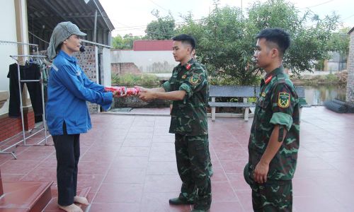 Bà Hoàng Thị Hòa chuẩn bị nước giải khát cho các chiến sĩ hỗ trợ gia đình vận chuyển tài sản.