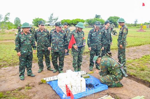 Lãnh đạo Bộ CHQS tỉnh và Chỉ huy Trung đoàn 894 theo dõi, động viên chiến sĩ mới thực hành tra lắp đồ dùng gây nổ.