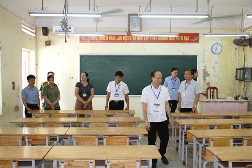Phó Chủ tịch UBND xã Mỹ Đức Phạm Trọng Của (hàng đầu) kiểm tra công tác chuẩn bị phòng thi tại điểm thi trường THPT Mỹ Đức A. Ảnh: VB