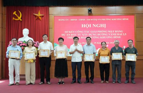 Bí thư Đảng ủy, Chủ tịch HĐND phường Khương Đình Võ Đăng Dũng trao tặng Giấy khen cho các hộ gia đình, cá nhân có nhiều đóng góp trong công tác GPMB dự án đường Vành đai 2,5 trên địa bàn phường. Ảnh: Hồng Thái