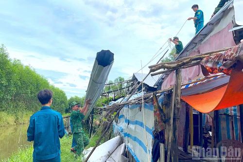 Cán bộ, chiến sĩ Đồn biên phòng Khánh Tiến cùng lực lượng Quân sự xã U Minh (tỉnh Cà Mau) hỗ trợ người dân che chắn lại nhà sau thiên tai.