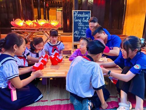 Học sinh được các anh chị hướng dẫn làm đèn hoa đăng.