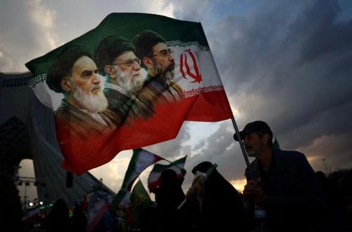 Cờ in chân dung của 3 lãnh tụ tối cao Iran được giương lên trong một cuộc tuần hành ở Tehran. (Ảnh: AP)