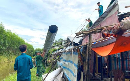 Cán bộ, chiến sĩ Đồn biên phòng Khánh Tiến cùng lực lượng Quân sự xã U Minh giúp người dân khắc phục hậu quả thiên tai.