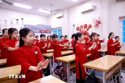 Trong tà áo dài đỏ rực rỡ, các học sinh say sưa thực hiện những động tác múa hát Xoan nhịp nhàng, góp phần tái hiện không gian văn hóa truyền thống ngay giữa lớp học. (Ảnh: Hoàng Hùng/TTXVN)