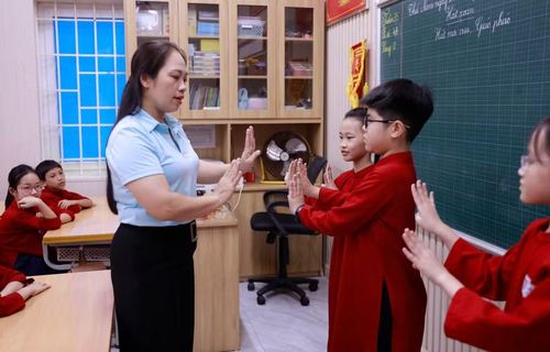 Cô Nguyễn Thị Hoàng Anh, Tổng phụ trách Đội Trường Tiểu học Gia Cẩm hướng dẫn học sinh chăm chú thực hành các động tác múa Xoan. (Ảnh: Hoàng Hùng/TTXVN)