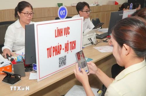 Người dân quét mã QR để tra cứu thủ tục và quy trình hồ sơ thuộc lĩnh vực tư pháp - hộ tịch. (Ảnh: Hữu Duyên/TTXVN)
