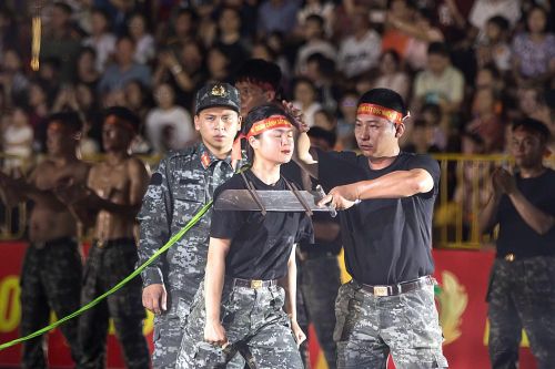Hạ sĩ Hoàng Thị Ngọc Linh chuẩn bị cho màn biểu diễn kê đao vào yết hầu để kéo xe 4 tấn.