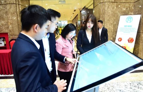 Đại biểu trải nghiệm ứng dụng chuyển đổi số dùng chung 3 cấp trong các cơ quan Đảng, chính quyền, Mặt trận Tổ quốc và các tổ chức chính trị - xã hội thành phố Hà Nội. Ảnh: Viết Thành