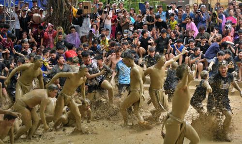 Thanh niên trong làng lao xuống sân tắm bùn chung vui cùng hai đội.