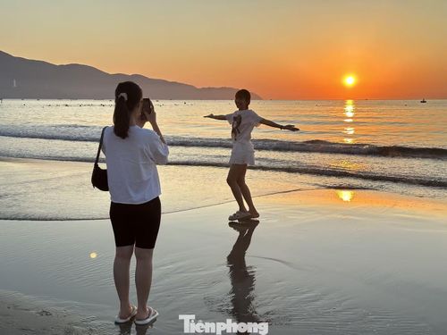  Nguyễn Thị Phương Thảo (27 tuổi) đến biển Mỹ Khê khi mặt trời vừa lên. “Mình chuyển đến Đà Nẵng được khoảng một năm nay. Vì ở gần biển nên khi mùa hè tới, mình thường dành thời gian chạy bộ và ngồi ngắm bình minh ở đây. Sáng nay mình dẫn bạn đến biển để chụp hình kỷ niệm”, Thảo kể. Ảnh: Khánh Đoan 