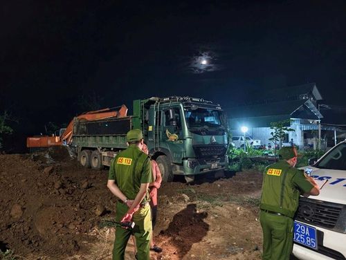 Lực lượng chức năng kiểm tra hiện trường, ngăn chặn hành vi đổ thải trái phép tại khu vực cầu Sông Nhuệ, xã Phượng Dực. Ảnh: CAHN