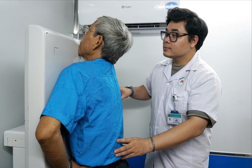 Nhân viên y tế hướng dẫn người lao động thực hiện chụp X-quang phổi kỹ thuật số. Ảnh: Trâm Anh