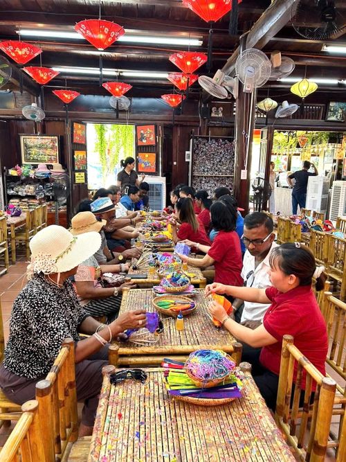 Du khách nước ngoài trải nghiệm làm lồng đèn Hội An. Ảnh: HOÀNG LINH